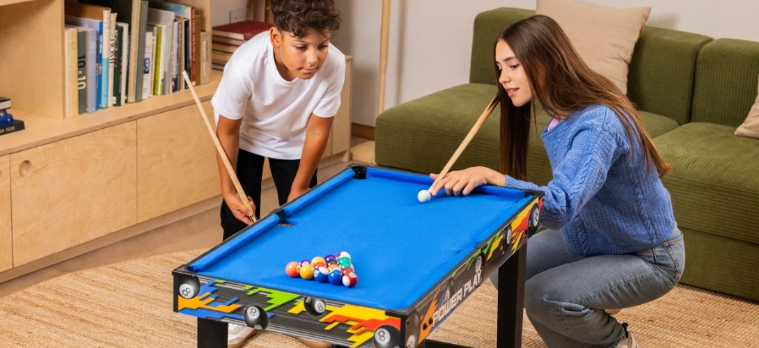 two teenagers playing pool on a standing games table