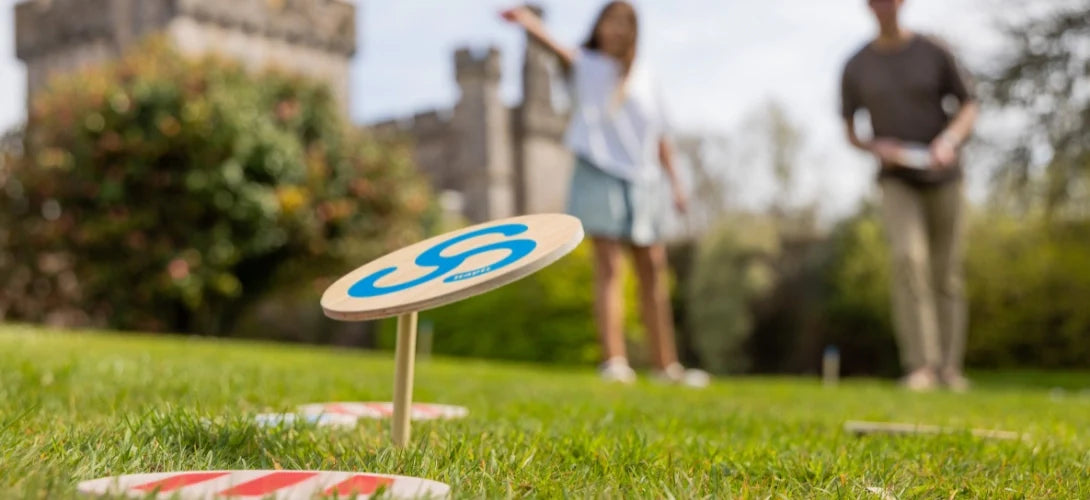 A young girl throwing Kapti discs with a parent