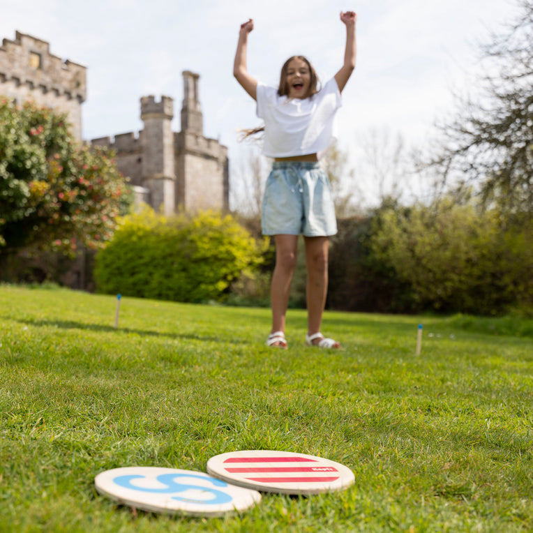 Kid playing throwing disc game in a park 